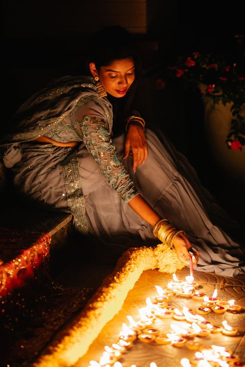 Free A woman in traditional attire lighting diyas during a Diwali celebration. Stock Photo