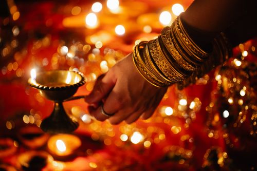 Free Close-up of a woman's hand holding a diya during a festive lighting ceremony. Stock Photo
