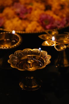 Golden oil lamps glowing amidst vibrant flowers, creating a warm, festive atmosphere.