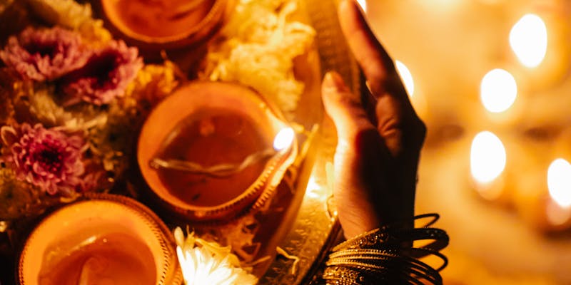 Woman holding diya platter during traditional Muhurat ceremony