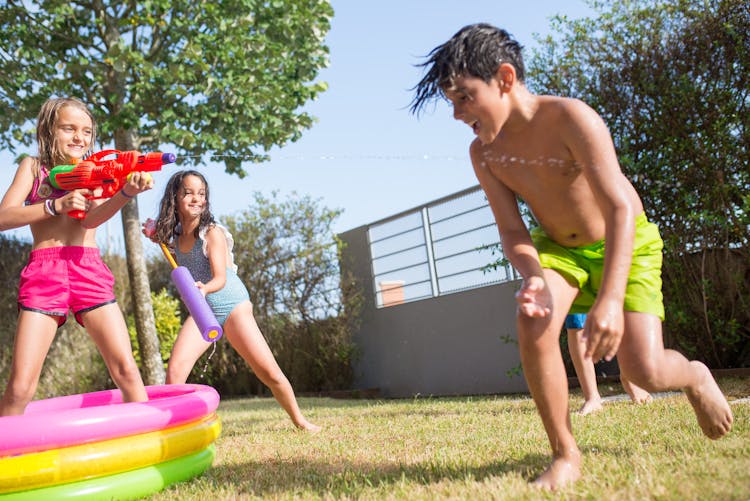 Children Playing Together At The Backyard