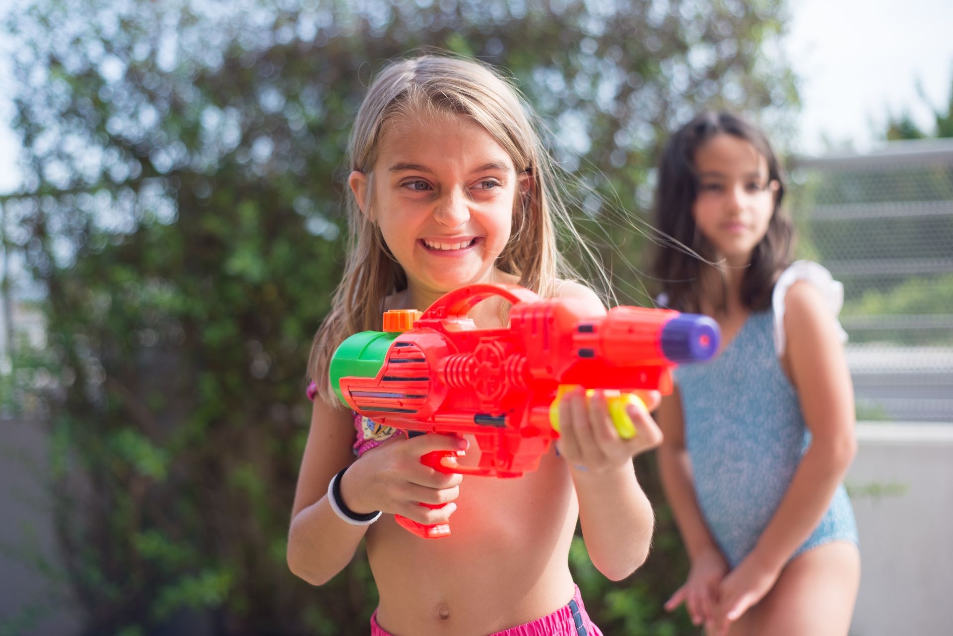 Young Girl Playing with a Water Gun
