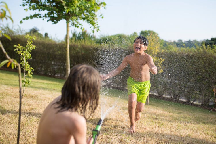 Boy In Green Shorts Playing Water