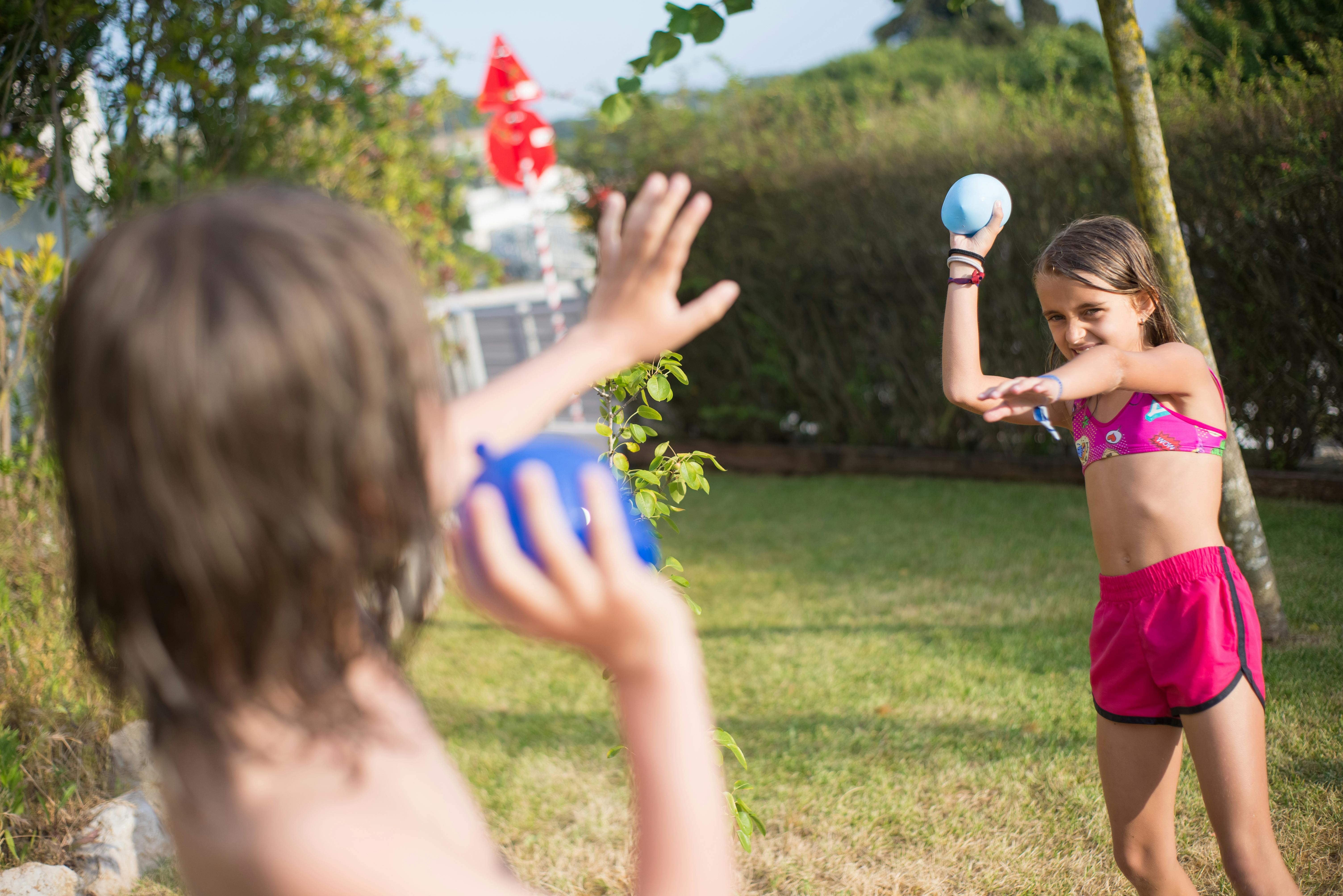 woman in red tank top holding blue ball