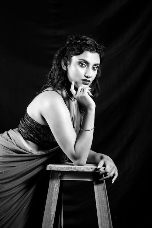 Free Elegant black and white portrait of a woman posing with a stool, showcasing fashion and poise. Stock Photo