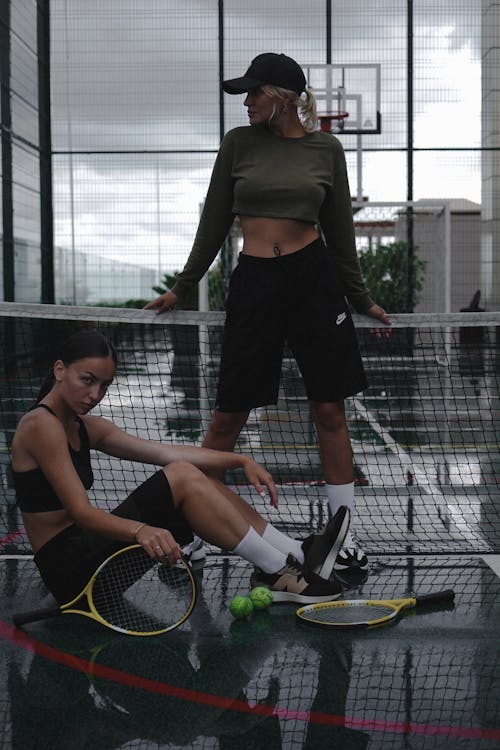 Women Posing on a Tennis Court with Sport Equipment