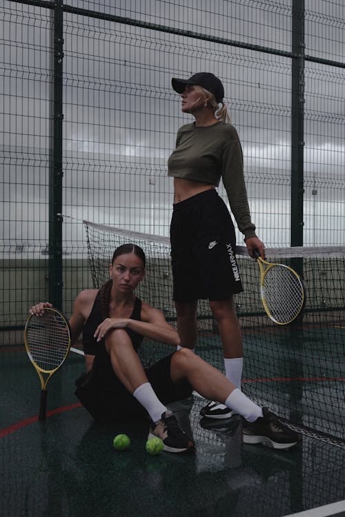 Women Posing with Rackets on Court