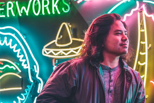 Portrait of a man in a leather jacket against vibrant neon signs, exuding urban energy.