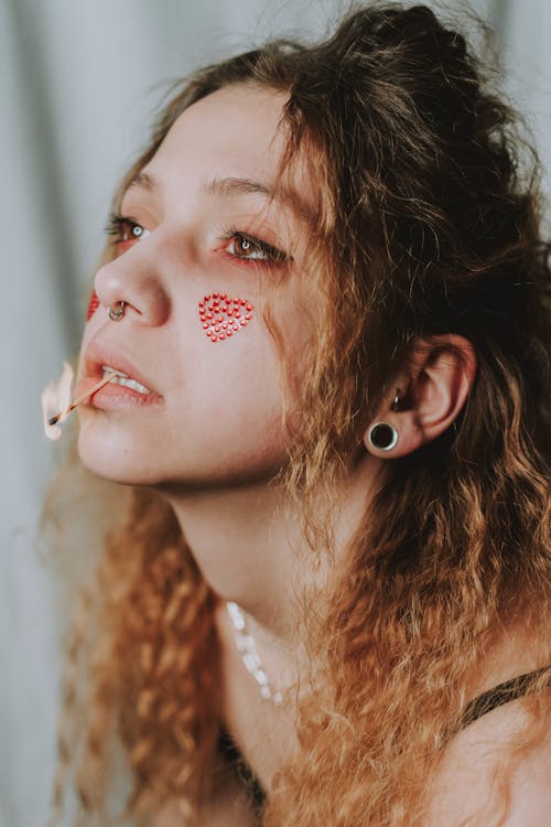 Close Up Shot of a Person with Match Stick on Her Lips