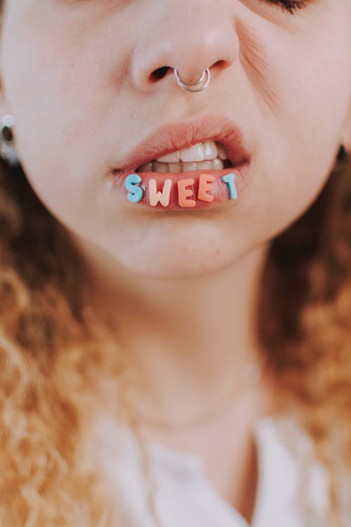 Crop Photo of Girl With Nose Ring and Letter Cutouts On Lips