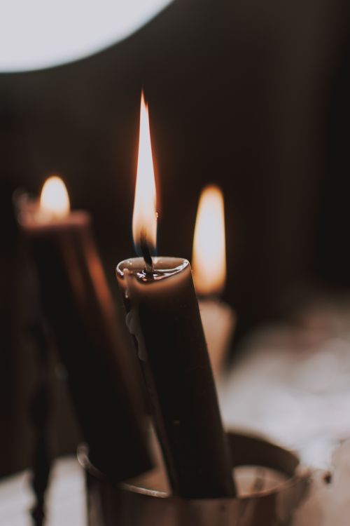 Free Three lit candles create a warm, intimate atmosphere with gentle flickering flames. Stock Photo