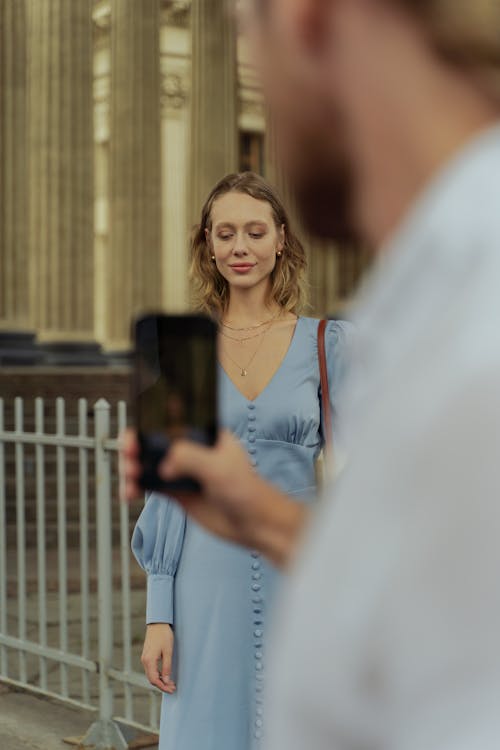 A Man Recording A Woman in Blue Dress 