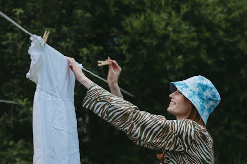 Free Woman Hanging A Dress on Clothesline For Drying Stock Photo