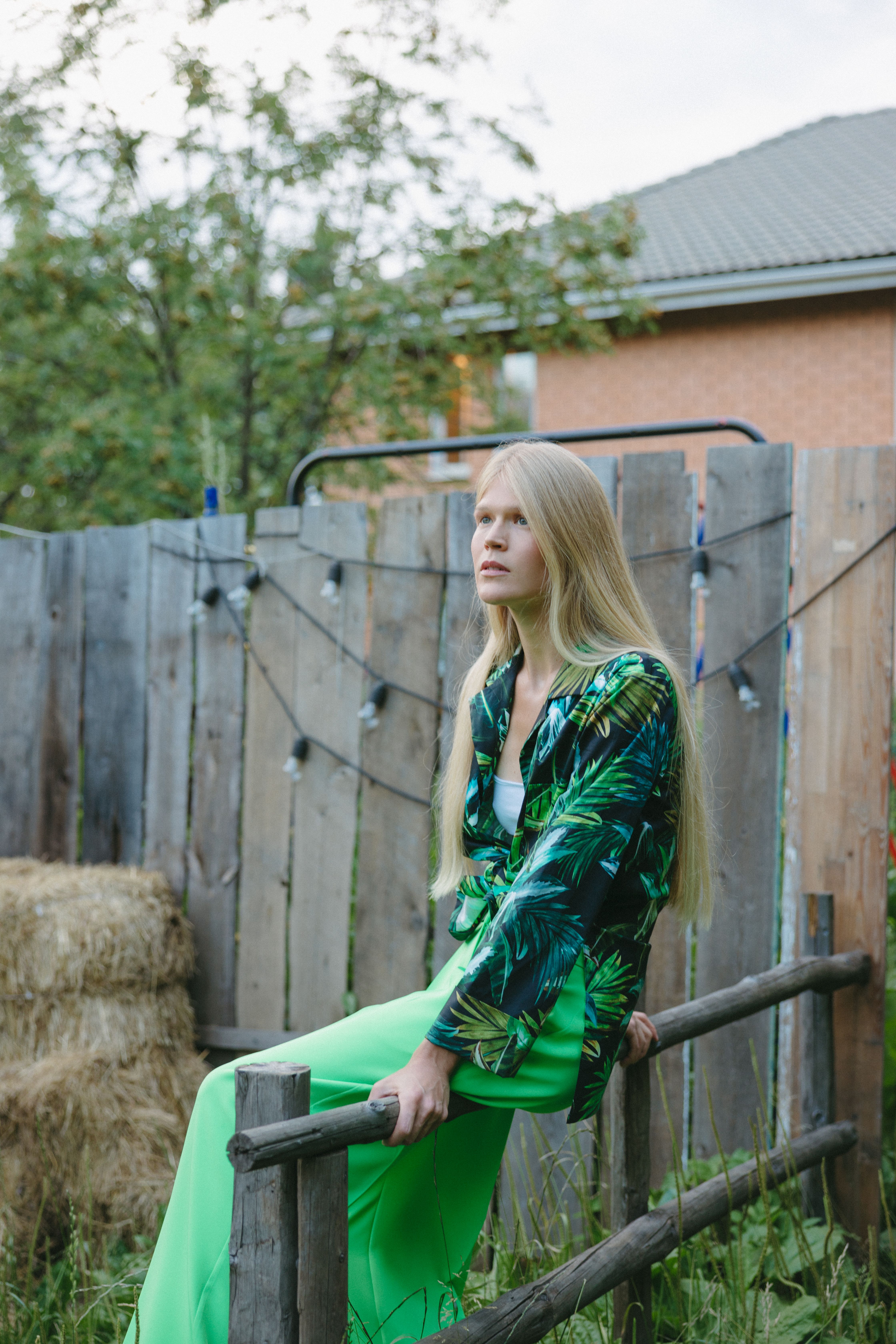 A Woman in Green Dress Sitting on the Wood Fence · Free Stock Photo