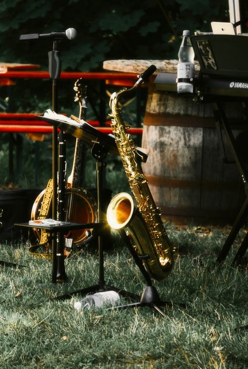 Free A serene outdoor music setup featuring a saxophone and other instruments on a grassy field. Perfect for event promotion. Stock Photo