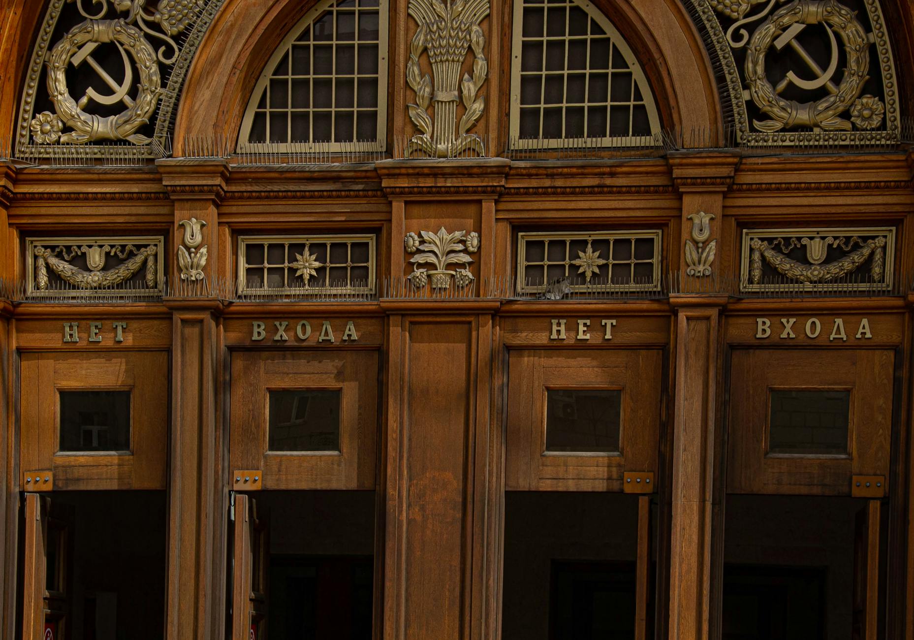 Intricate wooden entrance of a Moscow metro station displaying Soviet symbolism.