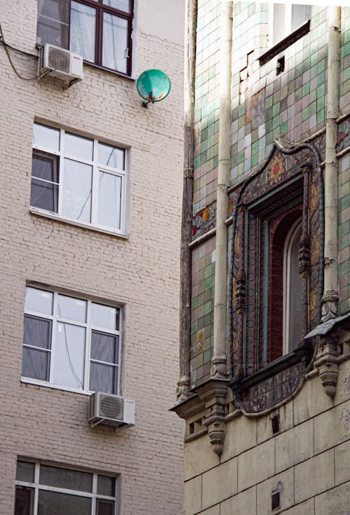 A Beige Apartment Building Beside Tiled Building 