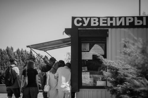 Free A group of people standing at a souvenir shop in a monochrome outdoor setting. Stock Photo
