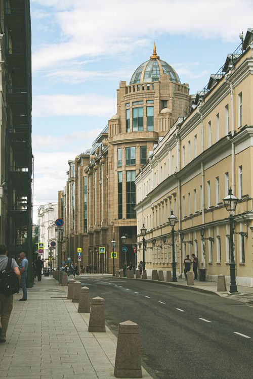 Free Street view of Moscow showcasing modern and classical architecture with pedestrians on a cloudy day. Stock Photo
