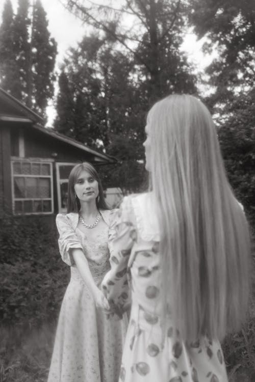 Grayscale Photo of Women Holding Hands 