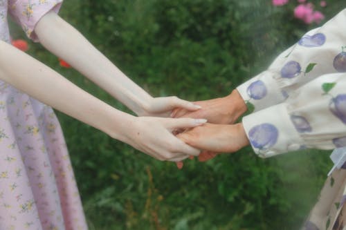 Free Shallow Focus of Two People Holding Hands Together Stock Photo