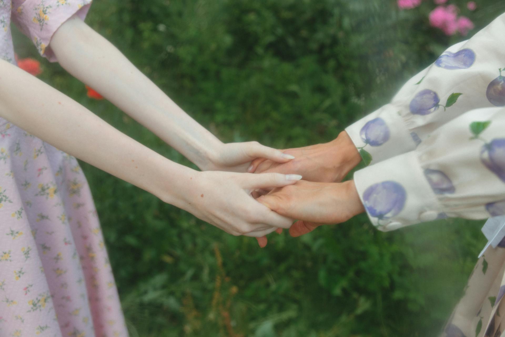 Shallow Focus of Two People Holding Hands Together