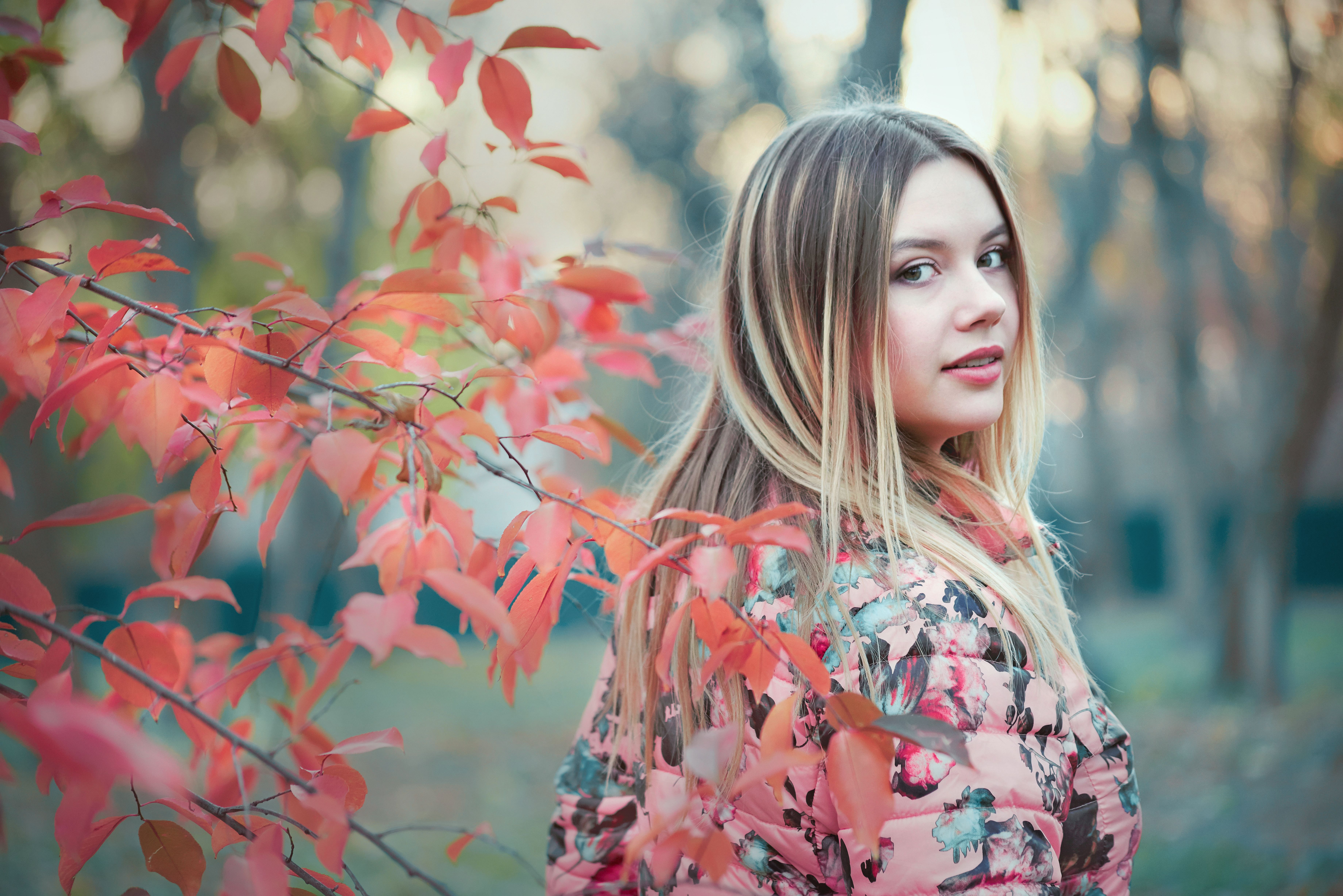 Woman in Pink Floral Long Sleeve Shirt Standing beside Pink Leaf Tree ...