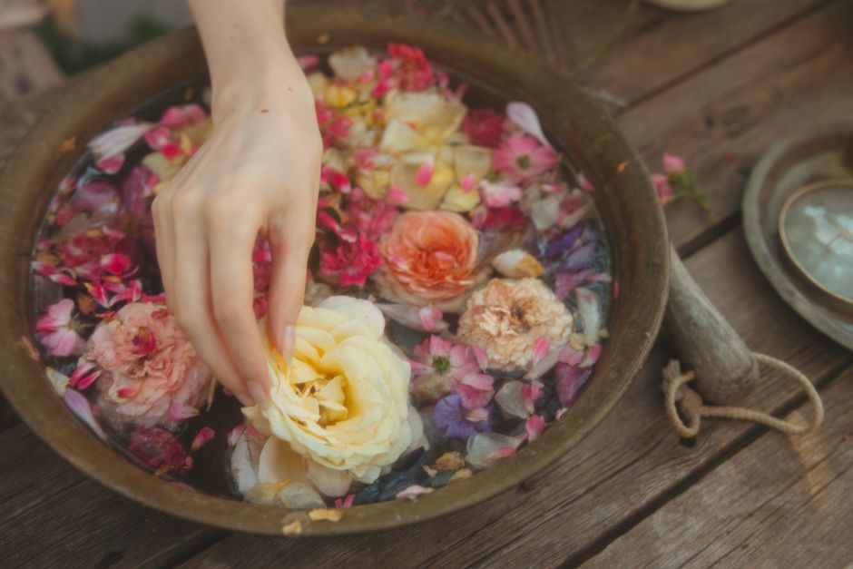 Pétales de fleurs naturelles dans un bol en bois pour préparer des soins hydrolats artisanaux