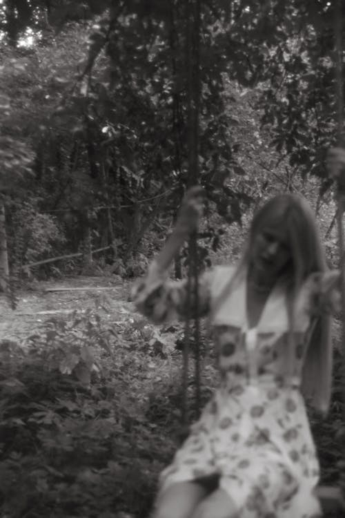 Free Grayscale Photo of Woman in Floral Dress Standing on Forest Stock Photo