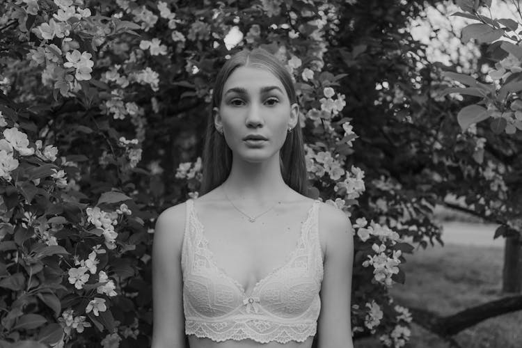 A Woman Wearing A Brassiere Surrounded By Flowers