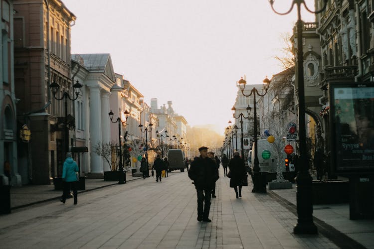 People Walking Old City Street On Sunset