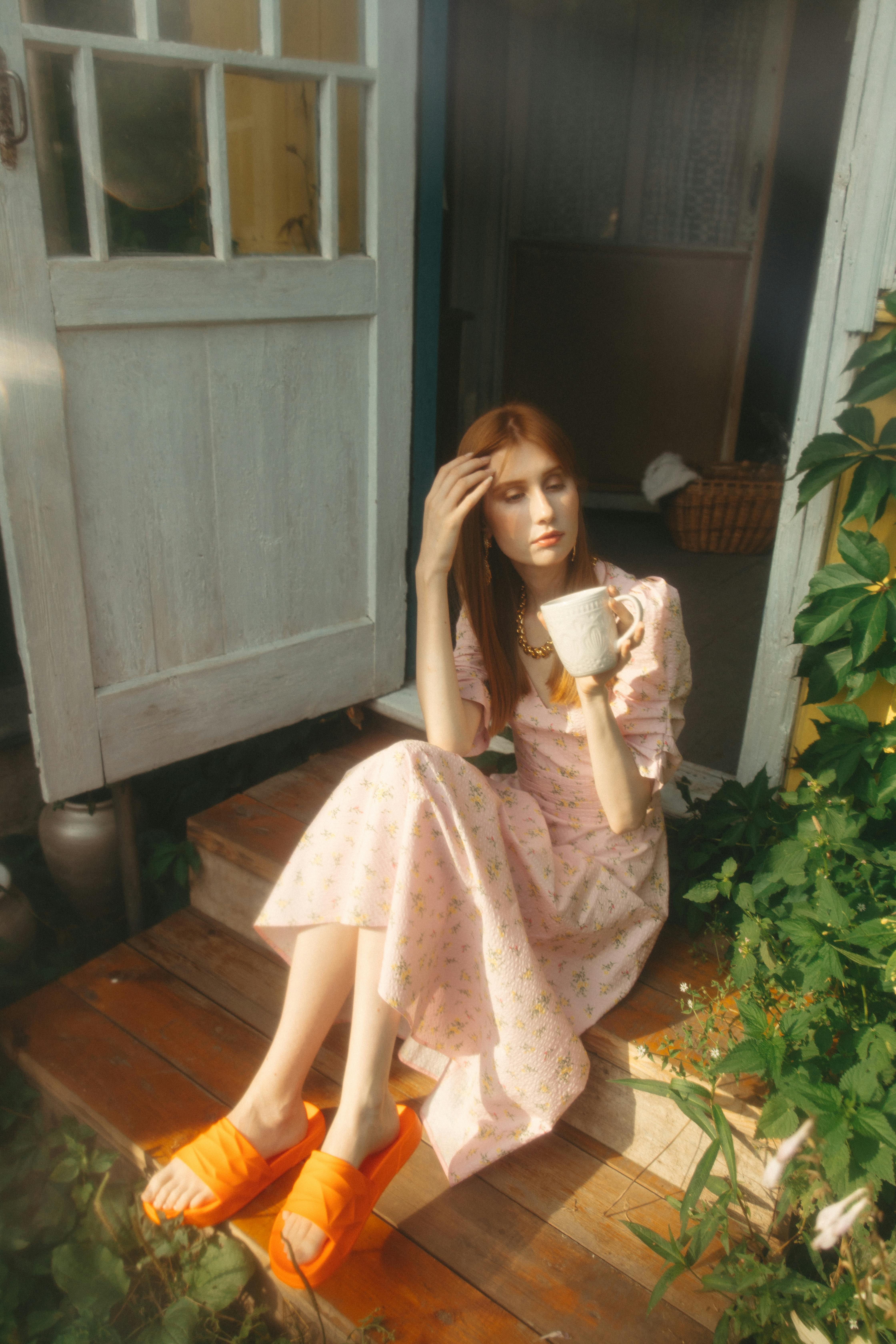 a woman holding a ceramic mug