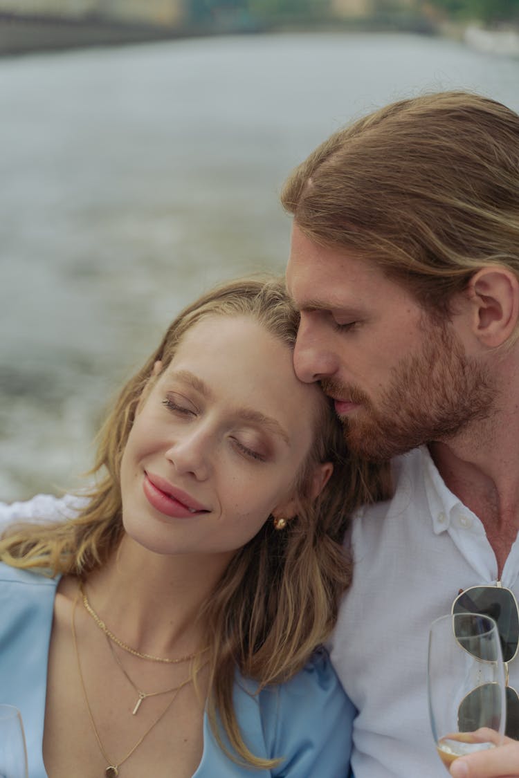 A Man Kissing A Woman On The Head