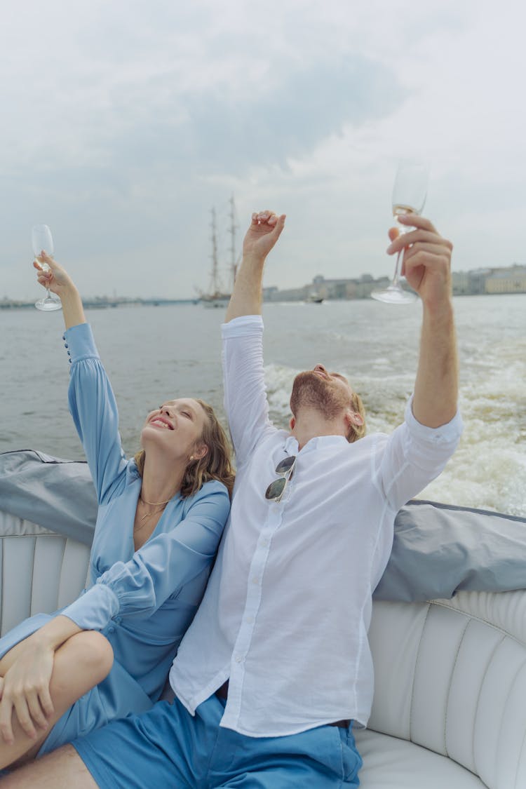 Man An Woman Enjoying Their Boat Trip While Drinking