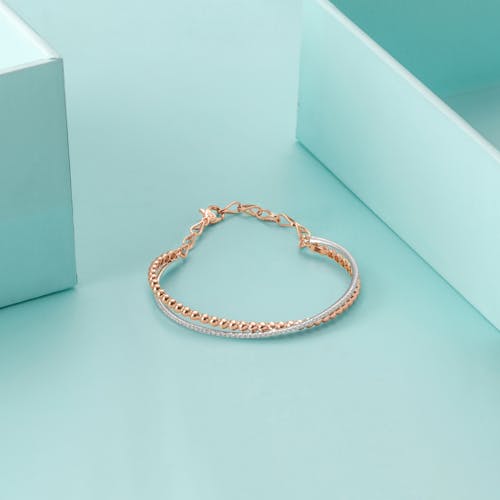 Gold Chain Link Bracelet in Teal Background