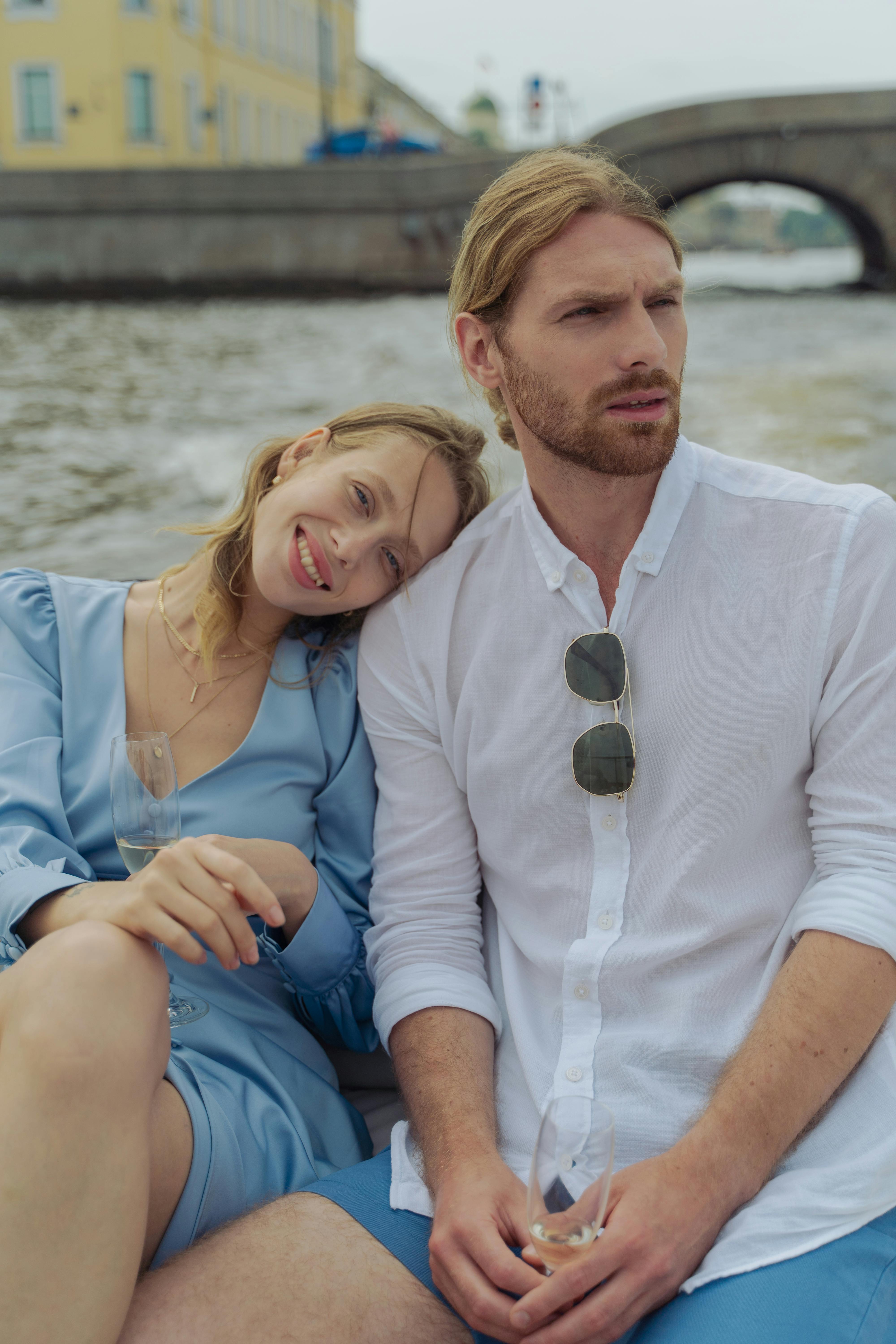 man in blue button up shirt sitting beside woman in blue dress