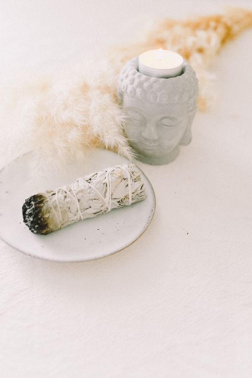 Free A serene arrangement featuring a sage bundle and candle for meditation in soft lighting. Stock Photo