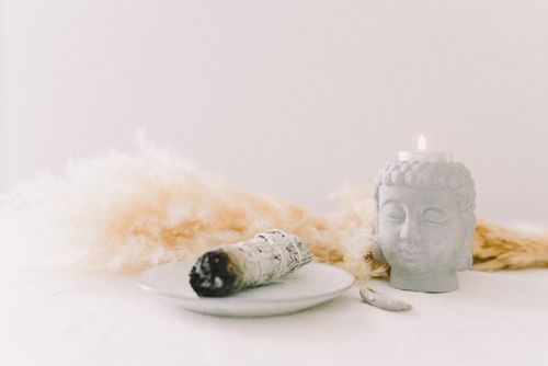 Free A peaceful still life featuring a sage bundle, Buddha candle holder, and pampas grass. Stock Photo