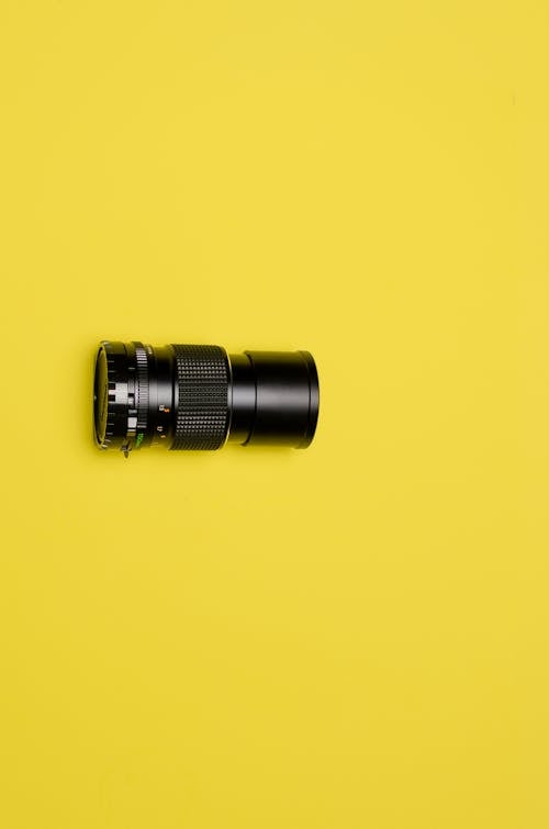 Black Camera Lens on Yellow Background