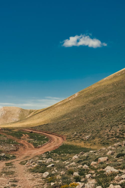 Dirt Road Near Green Mountain Under a Blue Sky