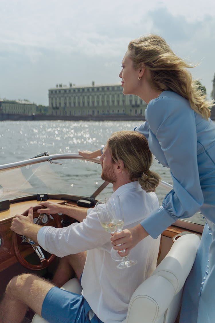 A Couple In The Boat While Holding Wine Glasses