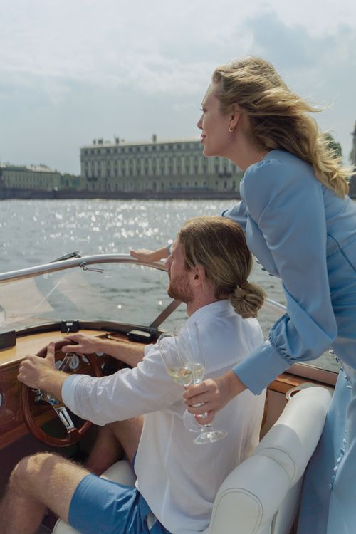 Free A sophisticated couple savoring a boat trip, holding wine glasses and enjoying the scenic view. Stock Photo