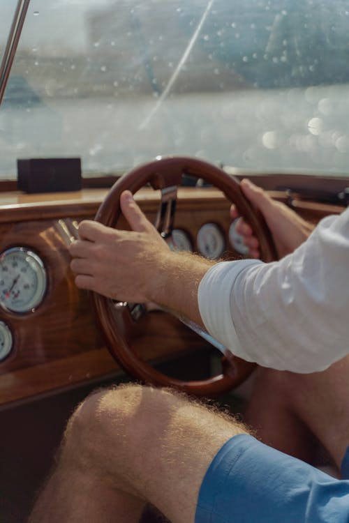 Free A Man Holding a Wooden Steering Wheel Stock Photo