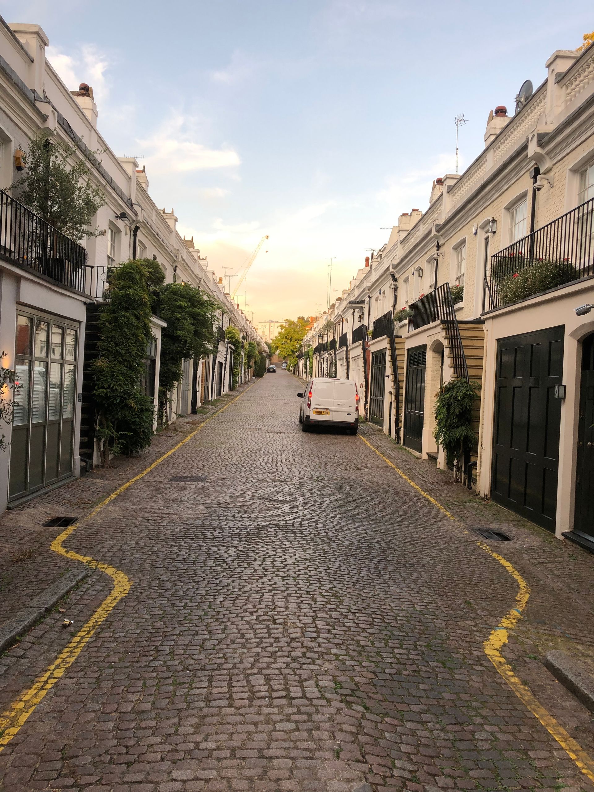 A golden-hour residential London crescent lined with period townhouses