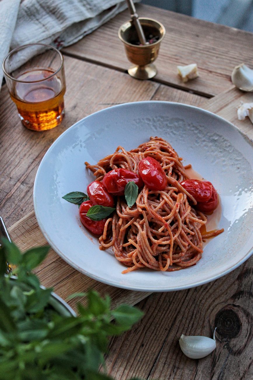 fresh handmade Italian pasta with tomato sauce on ceramic plate rustic table