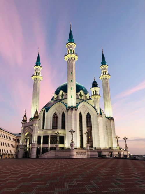 Free A stunning mosque with minarets stands tall under a dramatic evening sky, showcasing beautiful architecture. Stock Photo
