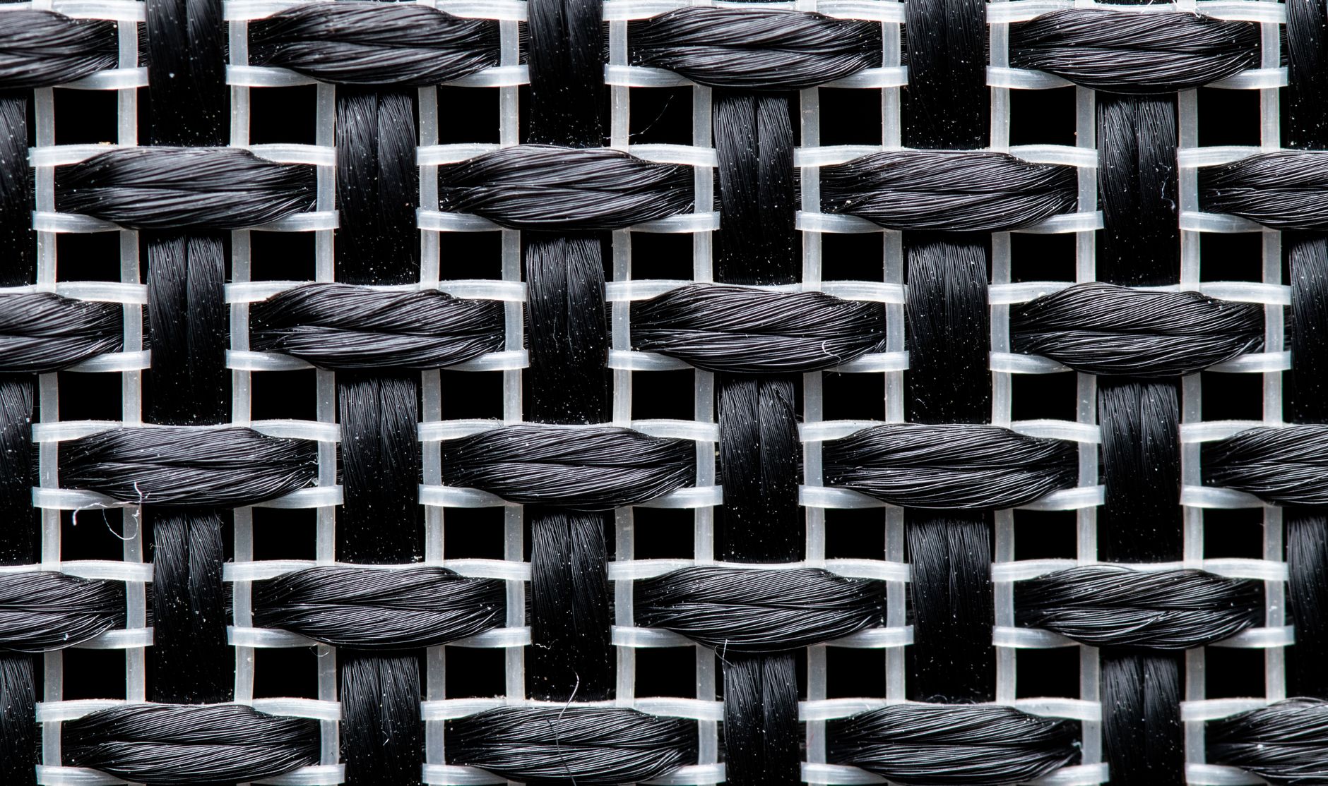 Close-up of woven merino wool fabric showing tight grid-like yarn intersections