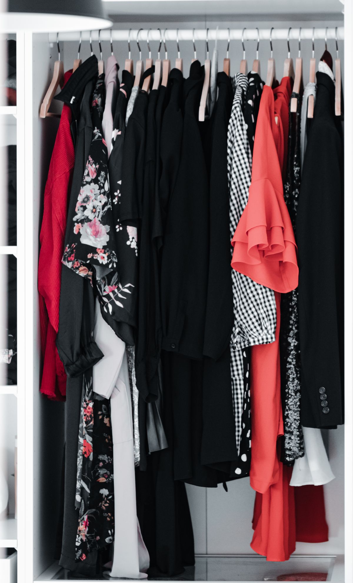 Neatly arranged wardrobe of clothes in varied styles and patterns on wooden hangers