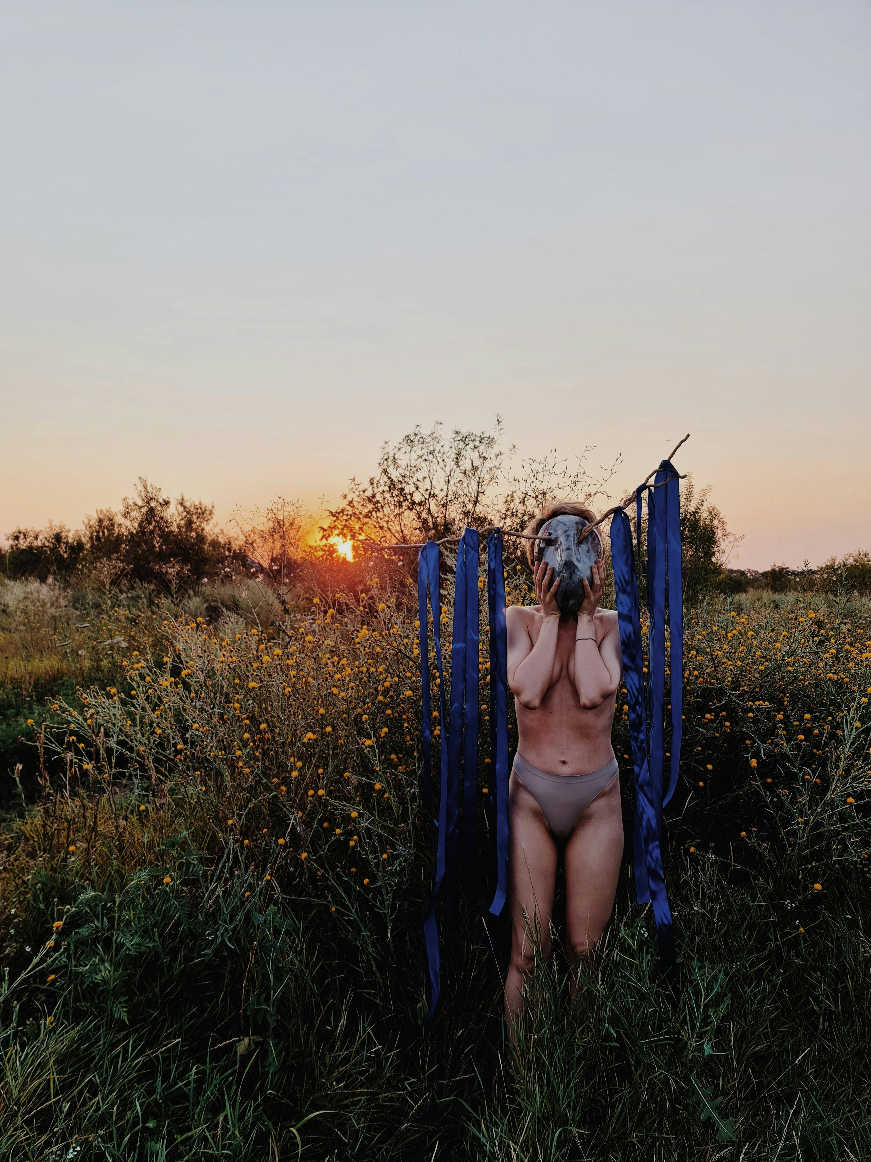 woman without clothes wearing a mask with blue cloth