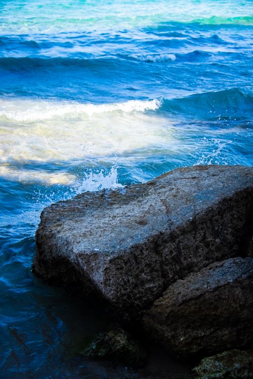 Free Dynamic ocean waves crashing against rocky shore in Benidorm, Spain's vibrant coastline. Stock Photo